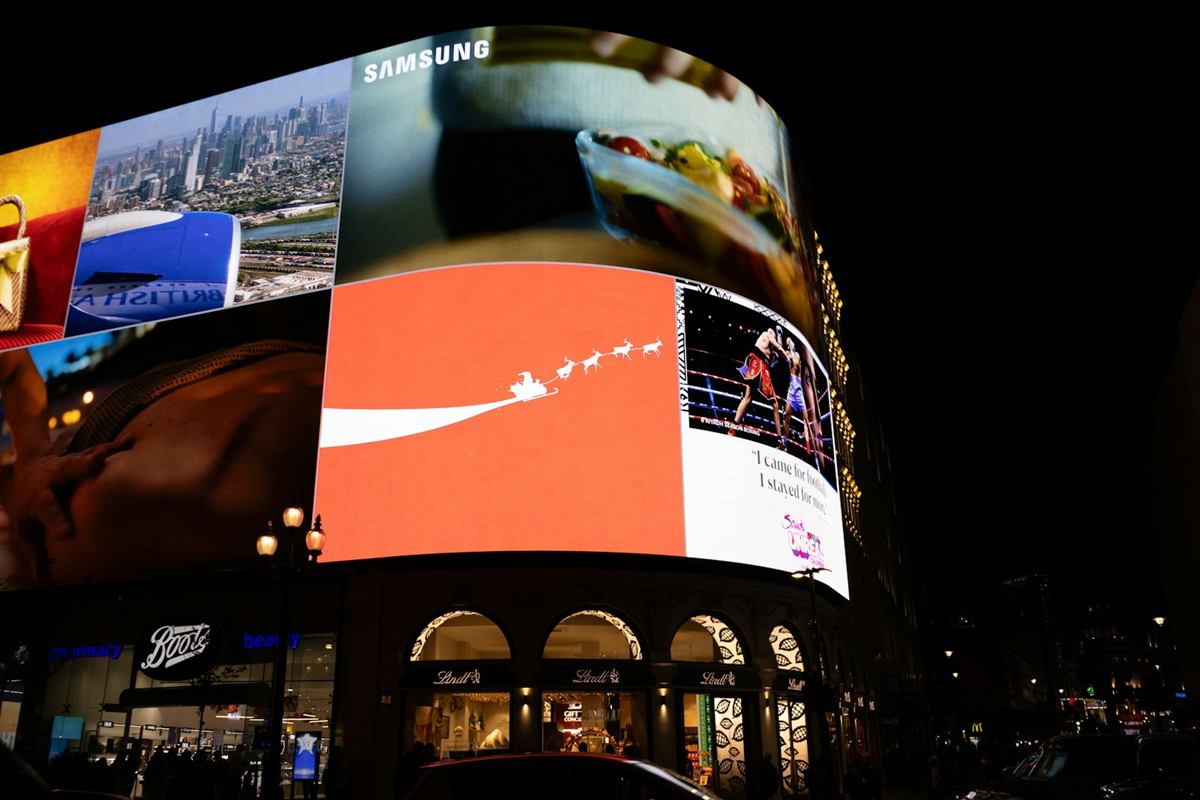 Curved digital LED billboard display in a busy city district